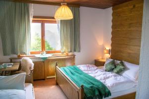 a bedroom with a bed and a desk and a window at Hochberghaus Resort in Grünau im Almtal