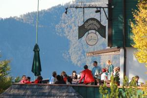 a group of people sitting at a restaurant at Hochberghaus Resort in Grünau im Almtal