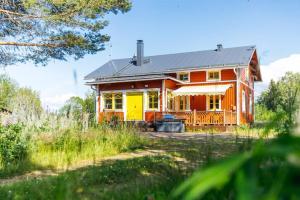 una casa rossa e gialla in un campo di Akselin Lomatupa a Kauhajoki Altre 2 foto