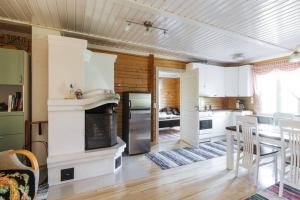 una cucina e una sala da pranzo con camino e tavolo di Akselin Lomatupa a Kauhajoki