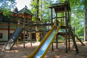 a playground with slides and a tree house at Hochberghaus Resort in Grünau im Almtal