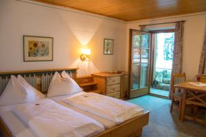 a bedroom with a large bed and a desk and a window at Hochberghaus Resort in Grünau im Almtal