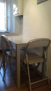 a table and chairs in a room with a kitchen at Torretta International in Trieste +11 photos