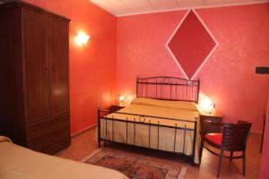 1 dormitorio con paredes rojas, 1 cama y 1 silla en B&B Rinascente, en Paola