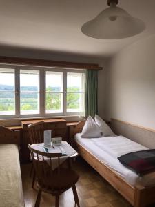a bedroom with a bed and a table and windows at Kloster Wernberg in Wernberg