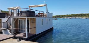 a small boat is docked on the water at House Boat - Floating House Sofia in Pula