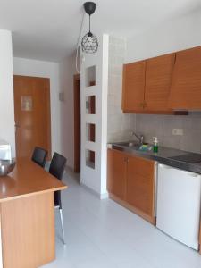 a kitchen with a refrigerator, stove, sink and a microwave at Aparthotel Golf Beach in Pals
