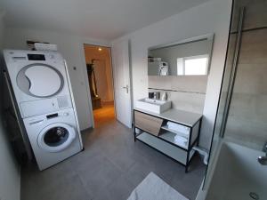 a bathroom with a washing machine and a sink at Duplex des montains in Loches