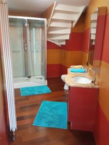 baño con lavabo y ducha con alfombras azules en spacieuse maison urbaine proche du centre ville en Béthune