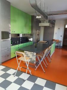 una cocina con armarios verdes, mesa y sillas en spacieuse maison urbaine proche du centre ville en Béthune