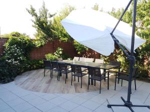 einen Tisch und Stühle mit Sonnenschirm auf einer Terrasse in der Unterkunft spacieuse maison urbaine proche du centre ville in Béthune