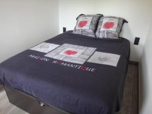 uma cama com uma colcha roxa com corações em MONT BLANC HOLIDAYS dans résidence avec Gardien em Sallanches