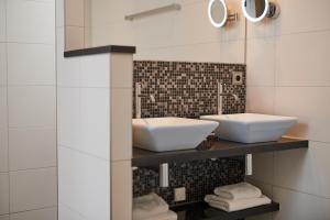 a bathroom with a sink and a mirror at Hotel De Lindeboom in Den Burg