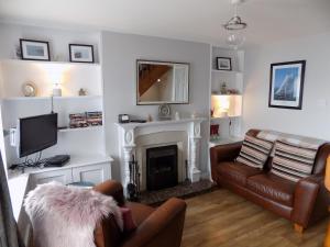 sala de estar con sofá y chimenea en Widows Row Cottage, en Newcastle