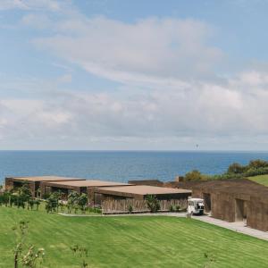a rendering of a building with the ocean in the background at Santa Barbara Eco-Beach Resort in Ribeira Grande