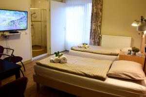 una camera d'albergo con due letti e una televisione di Stichting Veenloopcentrum Weiteveen a Weiteveen