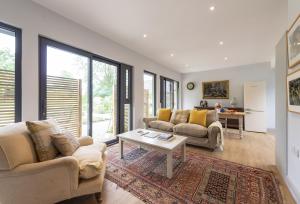 a living room with two couches and a table at Beauvoir Court Stables in Dorchester