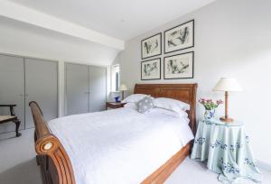 a bedroom with a large white bed with a table at Beauvoir Court Stables in Dorchester