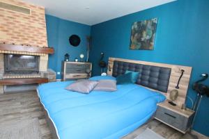 1 dormitorio azul con 1 cama y chimenea en Colmar City Center - Apartment Duplex MARIGNY - BookingAlsace, en Colmar