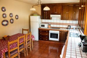 a kitchen with a table and a white refrigerator at Villas Las Cercas in El Paso