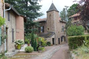 an alley in an old stone building with a tower at Chambres d'Hôtes La Courlande in Saint-Haon-le-Vieux