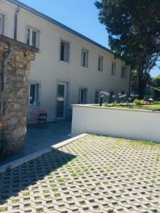 un gran edificio blanco con una pared blanca y un patio en B&B MonteCengio, en Trieste