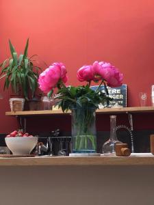 a vase of pink flowers sitting on a shelf at B&B Villa de Margot in Avignon