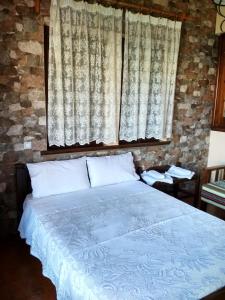 
a bed with a white bedspread and pillows at Christofer's Rooms in Zagora
