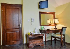 a room with a desk and a mirror and a chair at Hotel Mateo in Stopnica