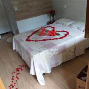 a bed with a heart made out of flowers on it at Pousada Preocupacao Zero in Ubajara