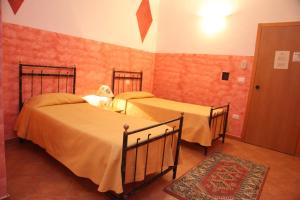 2 Betten in einem Zimmer mit roten Ziegelwänden in der Unterkunft B&B Rinascente in Paola