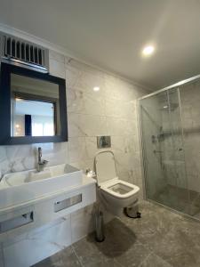 ein Bad mit einem Waschbecken, einem WC und einer Dusche in der Unterkunft DEDEHAN SUIT HOME in Trabzon
