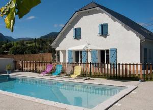 une maison avec une piscine en face d'une maison dans l'établissement Les 3 Edelweiss - GITE 1 OU GITE 2, à Arette
