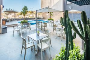 a patio with tables and chairs and a pool at Town Lodge Windhoek, Namibia in Windhoek