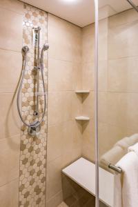 a shower with a glass door in a bathroom at Town Lodge Windhoek, Namibia in Windhoek
