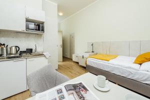 Apartmánový dom GRAND - Contactless Check In في ترينتشياسكي تيبليسي: غرفة بسرير ومطبخ مع طاولة
