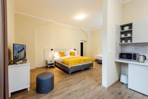 Apartmánový dom GRAND - Contactless Check In في ترينتشياسكي تيبليسي: غرفة نوم بسرير وتلفزيون في غرفة