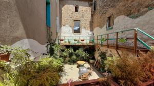 an outdoor patio with tables and plants in a building at Maison Mômes in Bize-Minervois