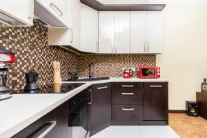 a kitchen with white cabinets and black appliances at Apartments Jaglana near Old Town by Renters in Gdańsk