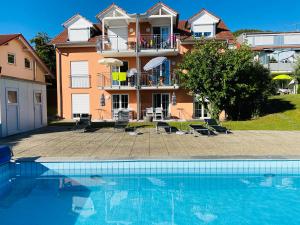 a house with a swimming pool in front of it at Das Schneckenhaus - Ferienwohnung mit Pool & Seeblick in Bodman-Ludwigshafen