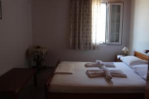 - une chambre avec un lit et des serviettes dans l'établissement Koula's Place, à Elafonisos