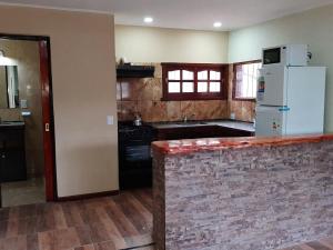 cocina con nevera blanca y encimera en Cabañas Layken en Villa Carlos Paz