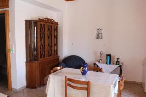 a dining room with a table and a cabinet at Koula's Place in Elafonisos
