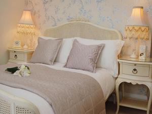 a white bed with two end tables and two lamps at amber house hotel in Paignton