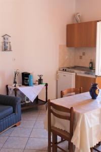 a living room with a table and a kitchen at Koula's Place in Elafonisos +13 photos