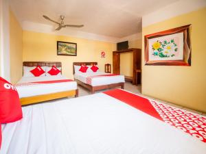 1 dormitorio con 2 camas con sábanas rojas y blancas en OYO Hotel Betsua Vista Hermosa, Huatulco, en Santa Cruz Huatulco