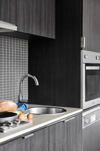 a kitchen with a sink and a microwave at Punthill South Yarra Grand in Melbourne