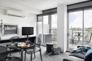 a living room with a couch and a table at Punthill South Yarra Grand in Melbourne