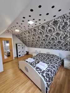 a bedroom with a bed with a black and white patterned wall at Casa de vacanță ZiaZian - Bărcut in Bărcuţ