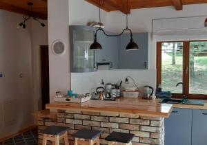 a kitchen with a brick counter with two stools at Pod Dębem Bis in Giby